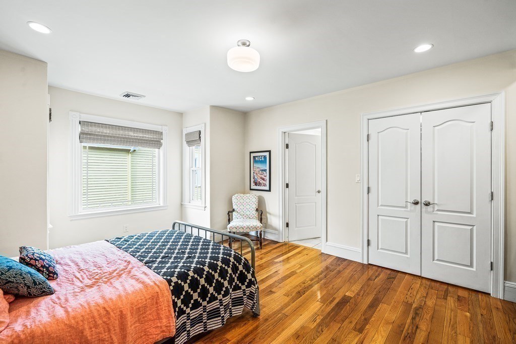 Bedroom with wide-plank hardwood flooring in Melrose, MA