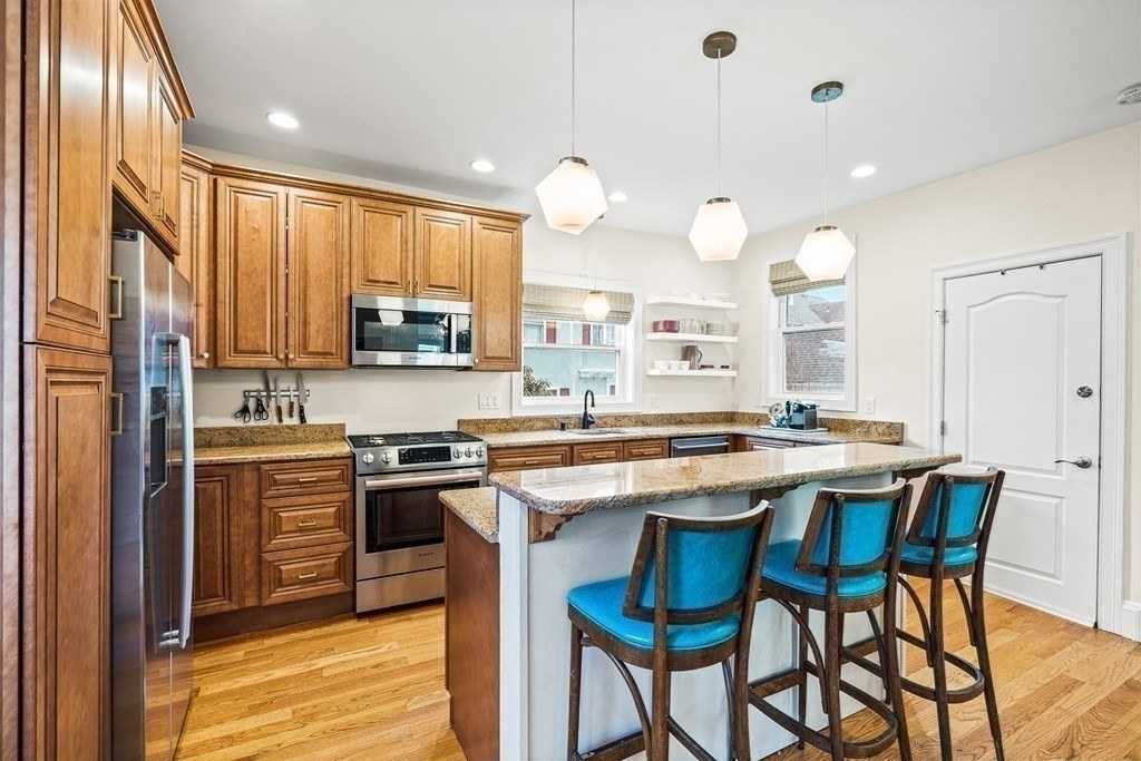 Custom kitchen with granite island and wood cabinetry in Melrose, MA